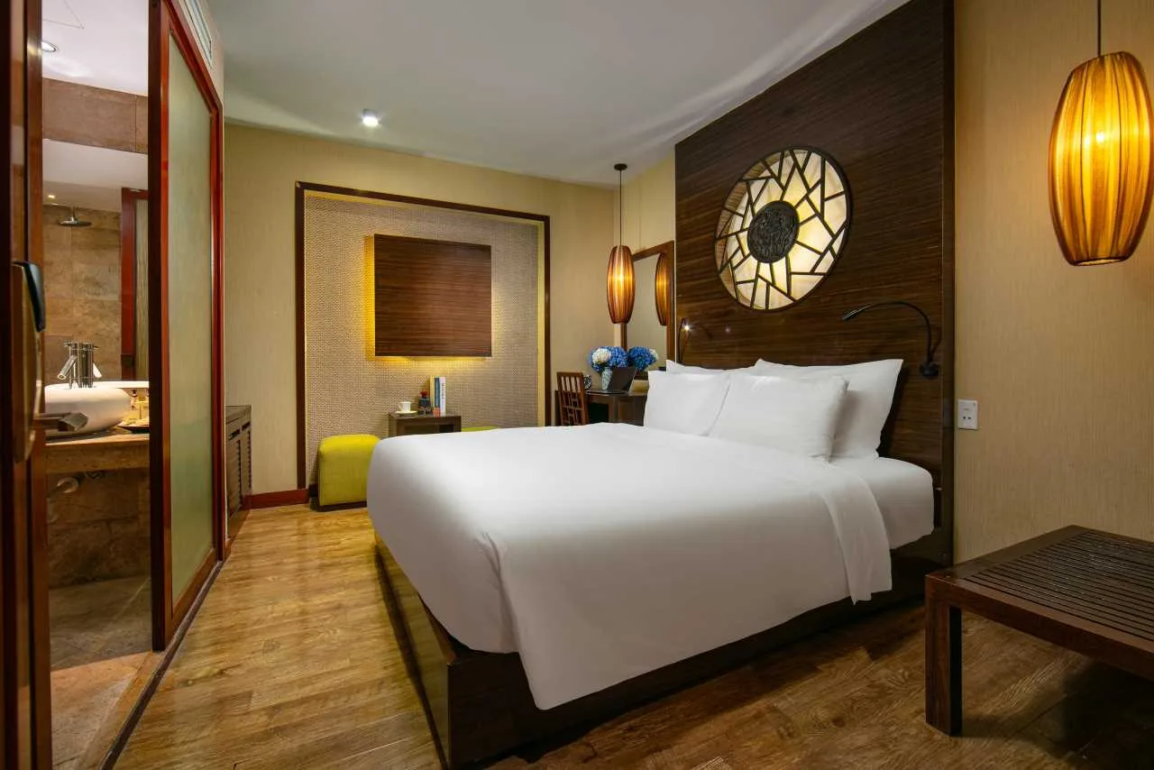 Espacio representativo del hotel: Un dormitorio de hotel con una cama grande y un elemento decorativo circular en la pared.