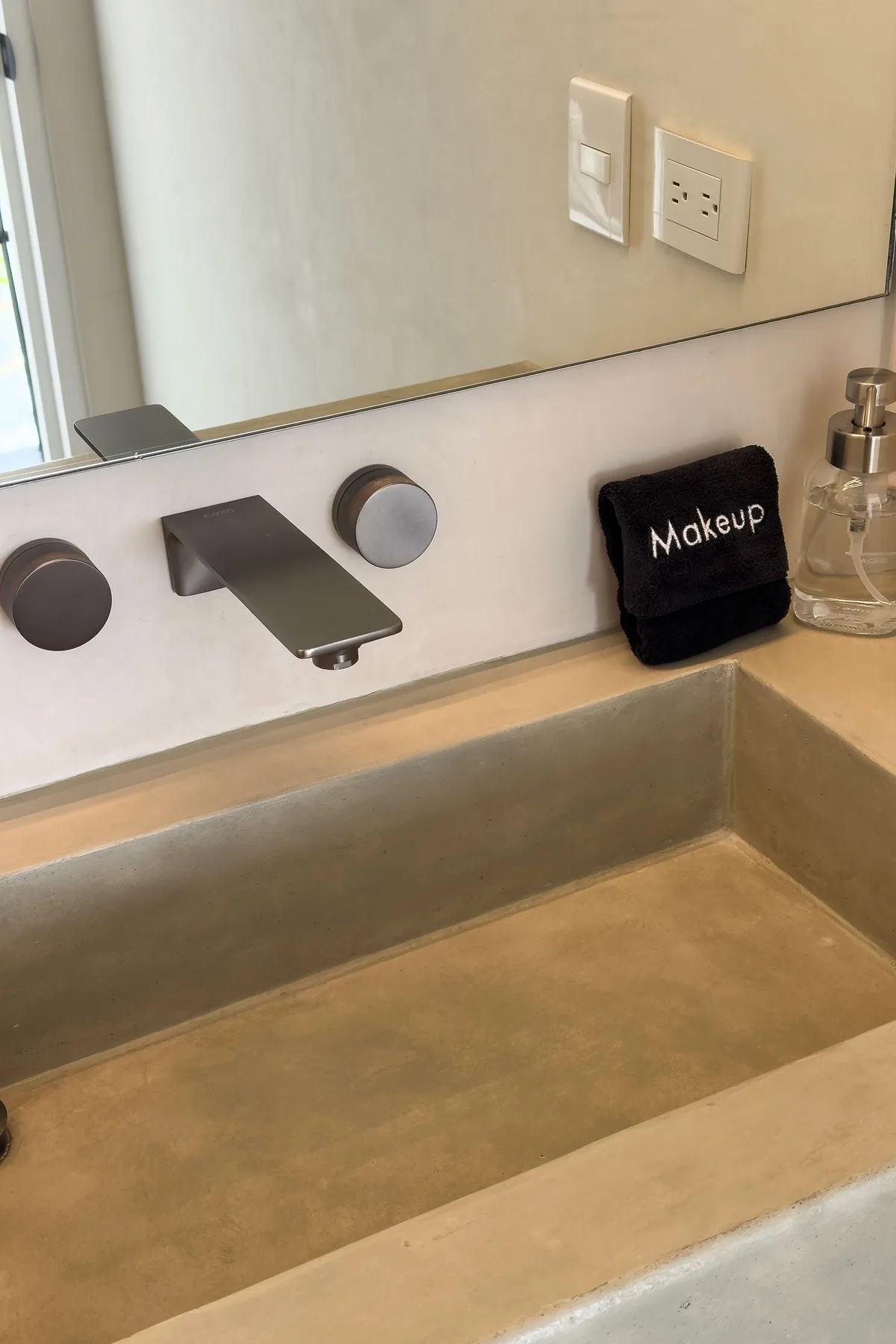A bathroom vanity with a rectangular sink and wall-mounted faucet.