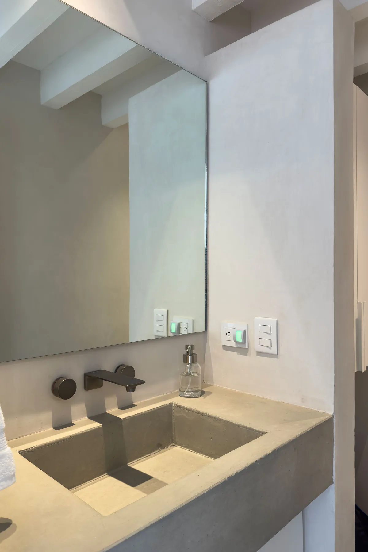 Bathroom vanity with a large mirror and a rectangular sink.