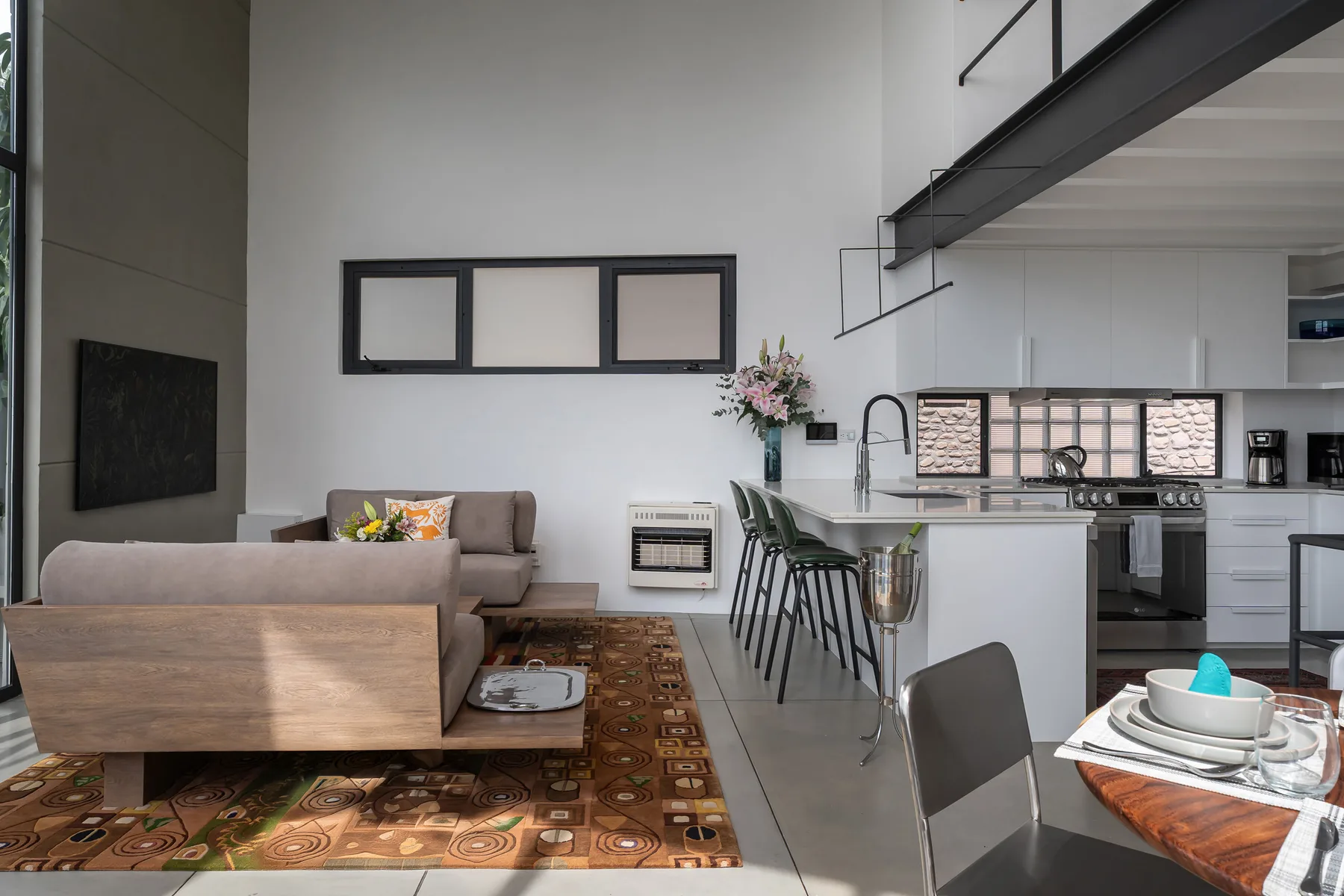 An open-plan living and kitchen area with a dining table and seating.