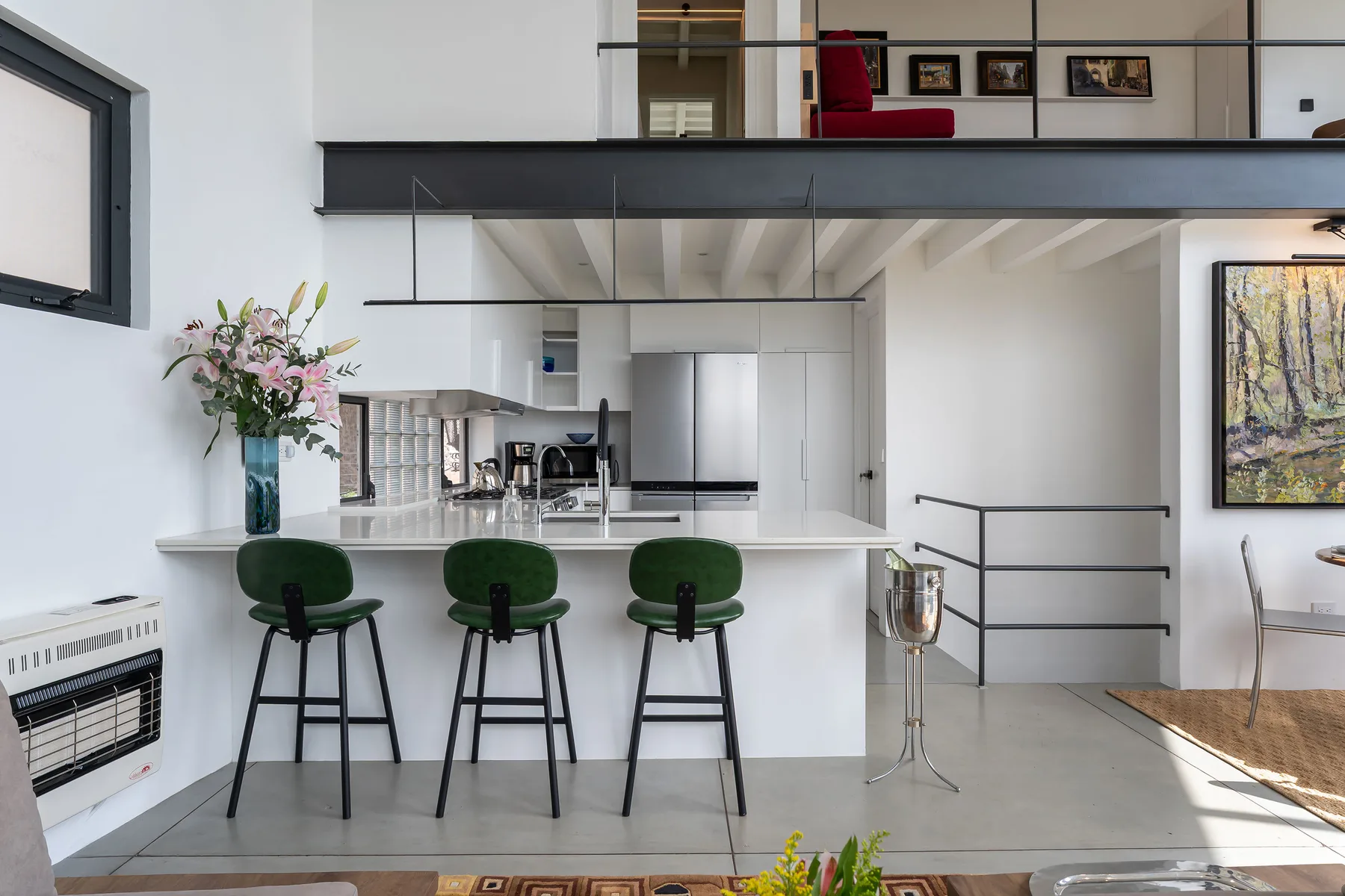 A bright open-plan kitchen and dining area features a long counter with bar seating.