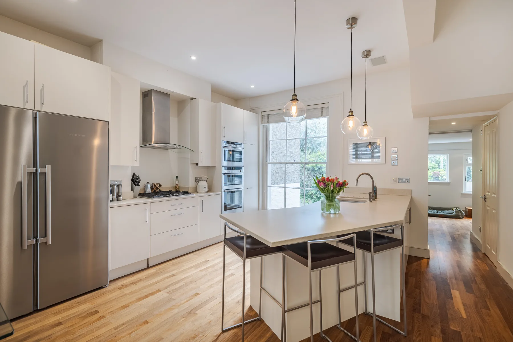A bright kitchen with a central island and stainless-steel appliances.