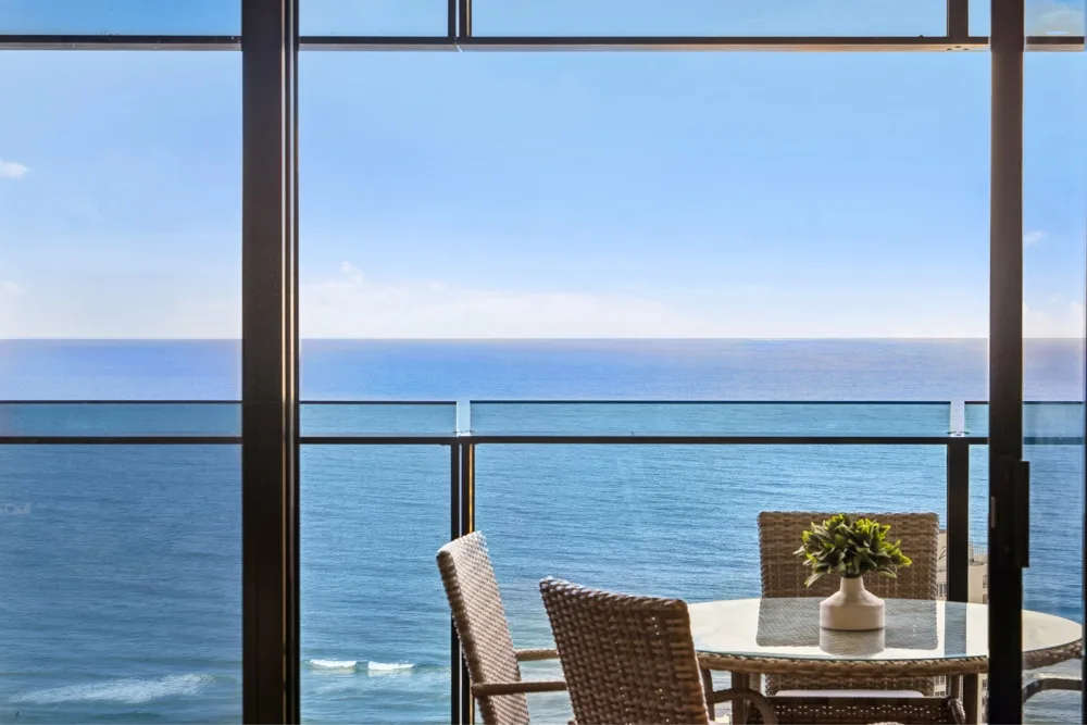 A seaside dining area overlooks the ocean through large windows.