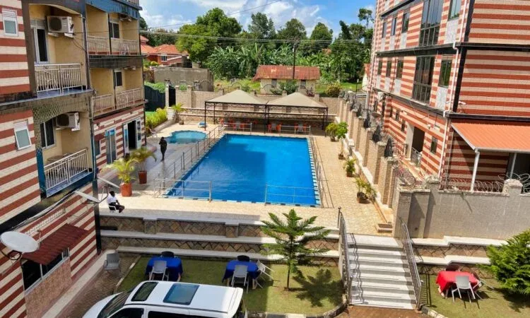 Representative hotel space: A swimming pool sits between multi-story buildings, with outdoor seating nearby.