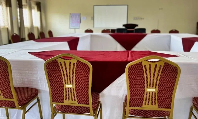 Representative hotel space: A meeting room arranged with tables covered in white cloths and red runners.