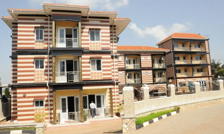 Representative hotel space: A striped multi-story hotel building with balconies stands beside a paved driveway.