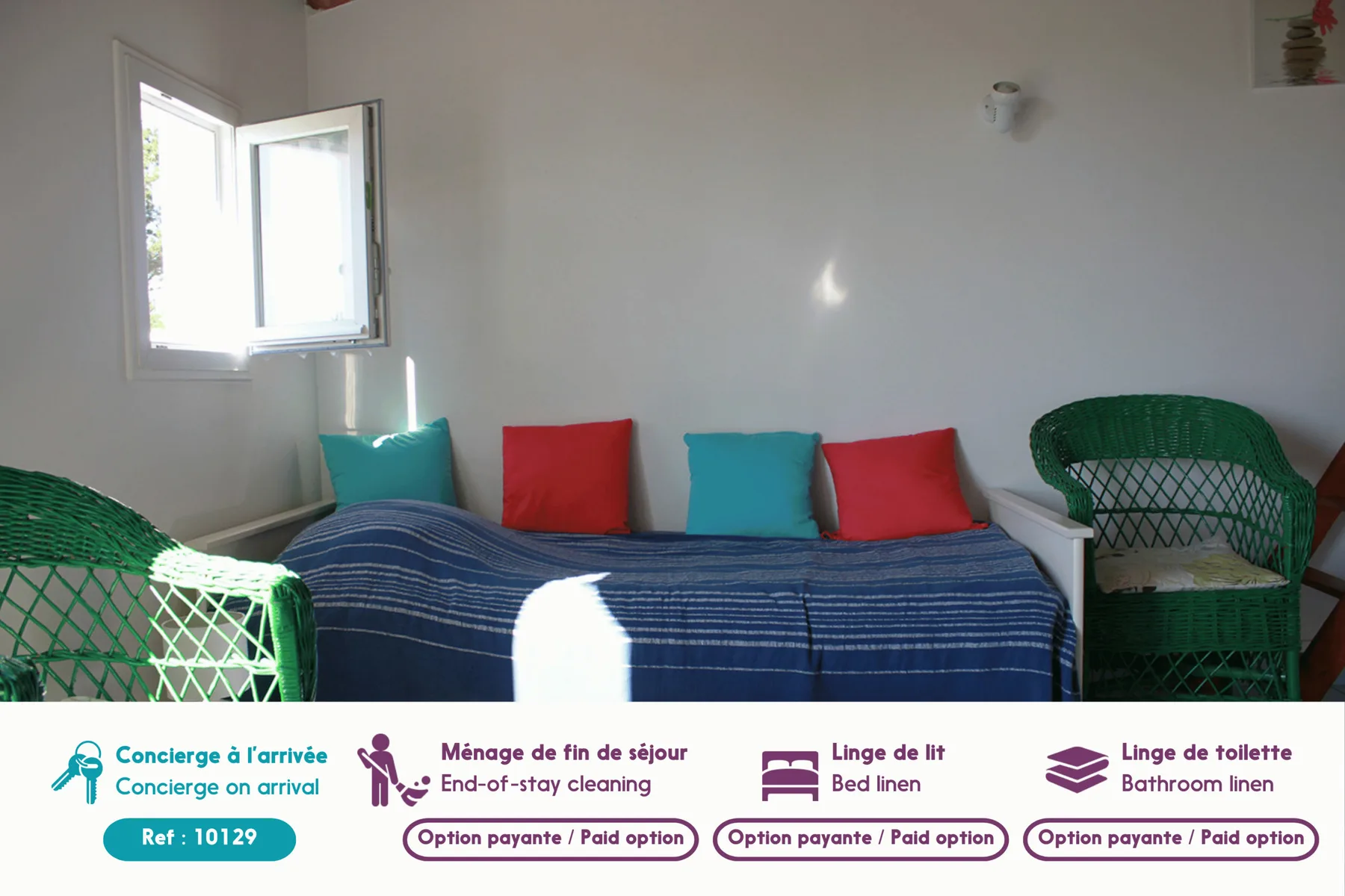 A bedroom with a bed, colorful cushions, and green woven seating.