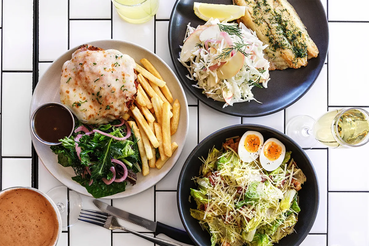 Representative hotel space: A meal spread with plated dishes and drinks on a tiled table.