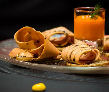 Representative hotel space: A plated savory dish sits beside a glass of orange-colored drink.