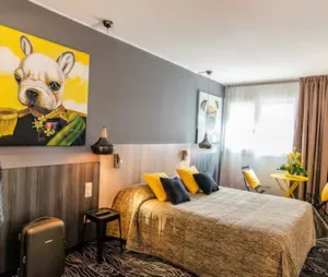 Representative hotel space: A bedroom with a bed, colorful cushions, and wall art.