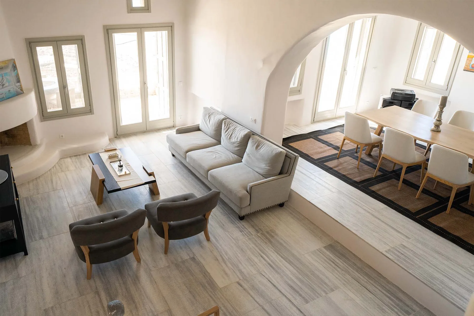 A bright living and dining area with seating arranged around a low table.