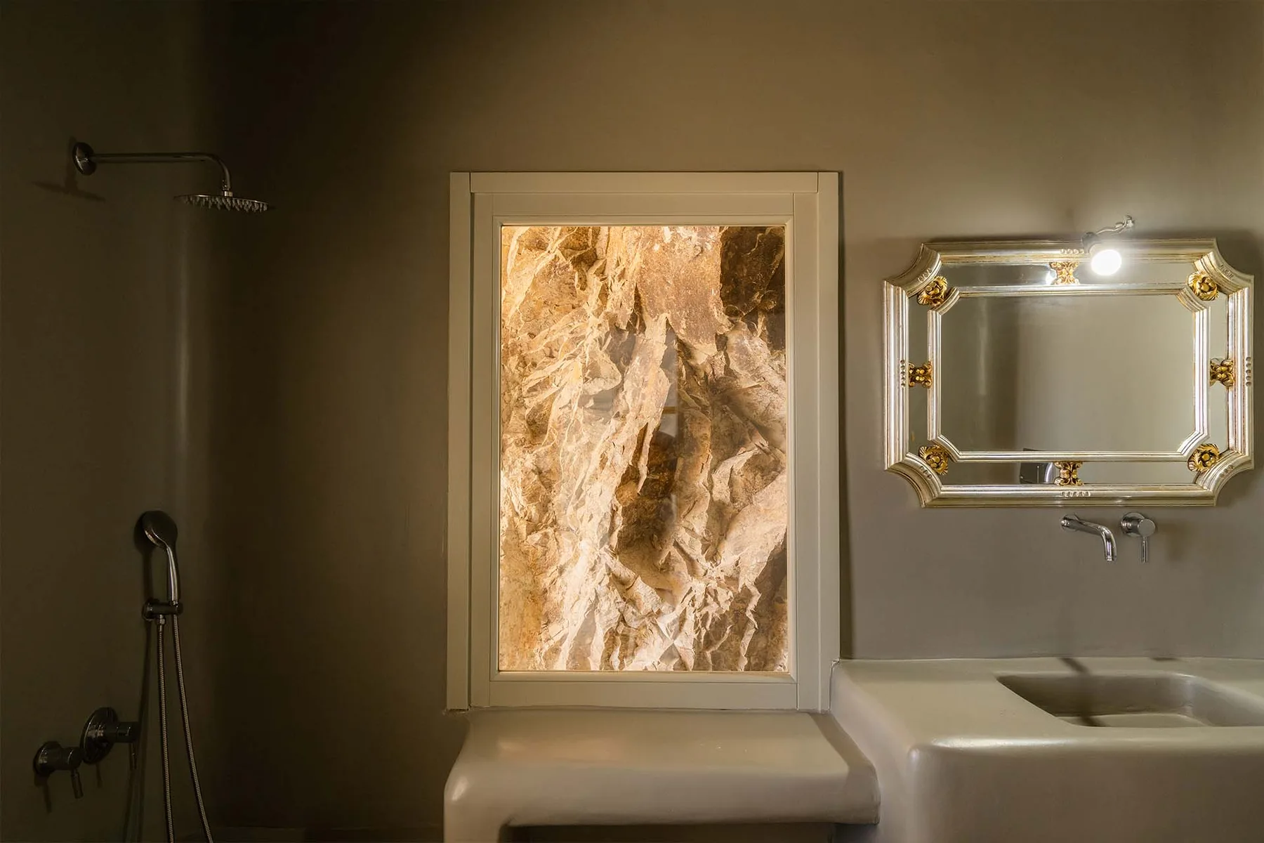 A bathroom vanity with a mirror and a brightly lit wall panel.