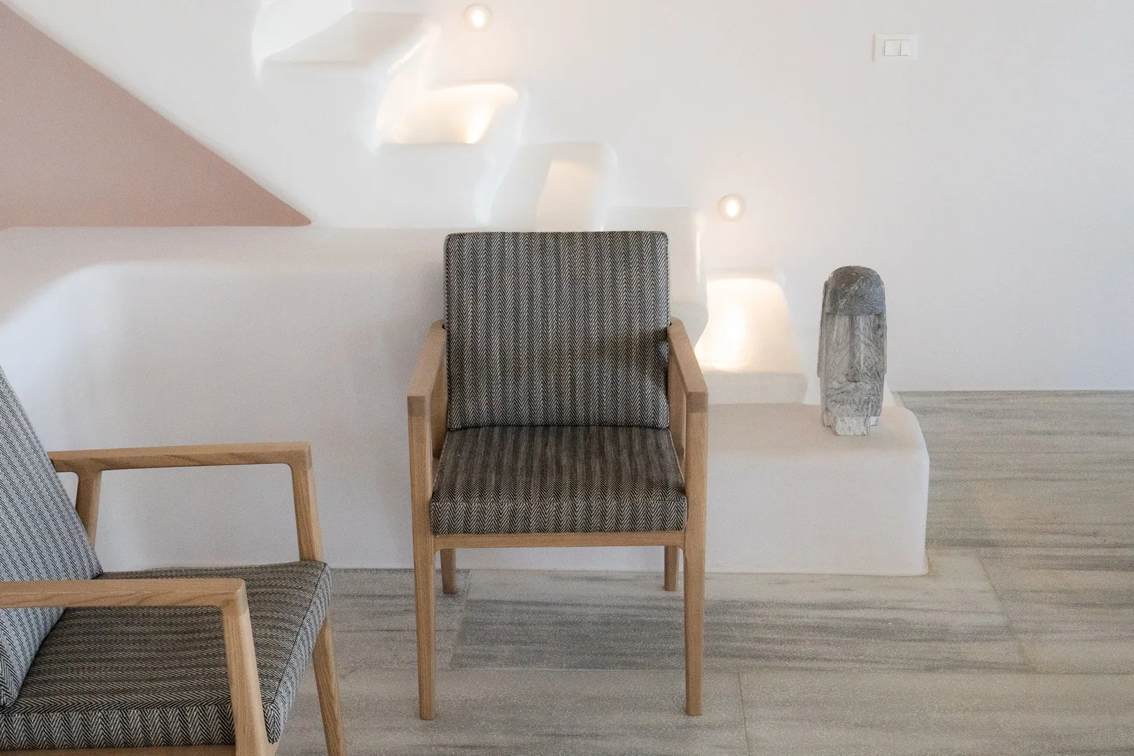 A bright sitting area with cushioned seating and softly lit wall niches.