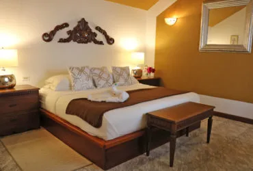 Representative hotel space: A warmly lit bedroom with a bed and a small table.
