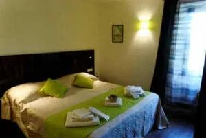 Representative hotel space: A bedroom with a bed and folded towels on the bedding.