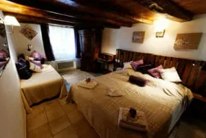 Representative hotel space: A bedroom with two beds and exposed wooden ceiling beams.