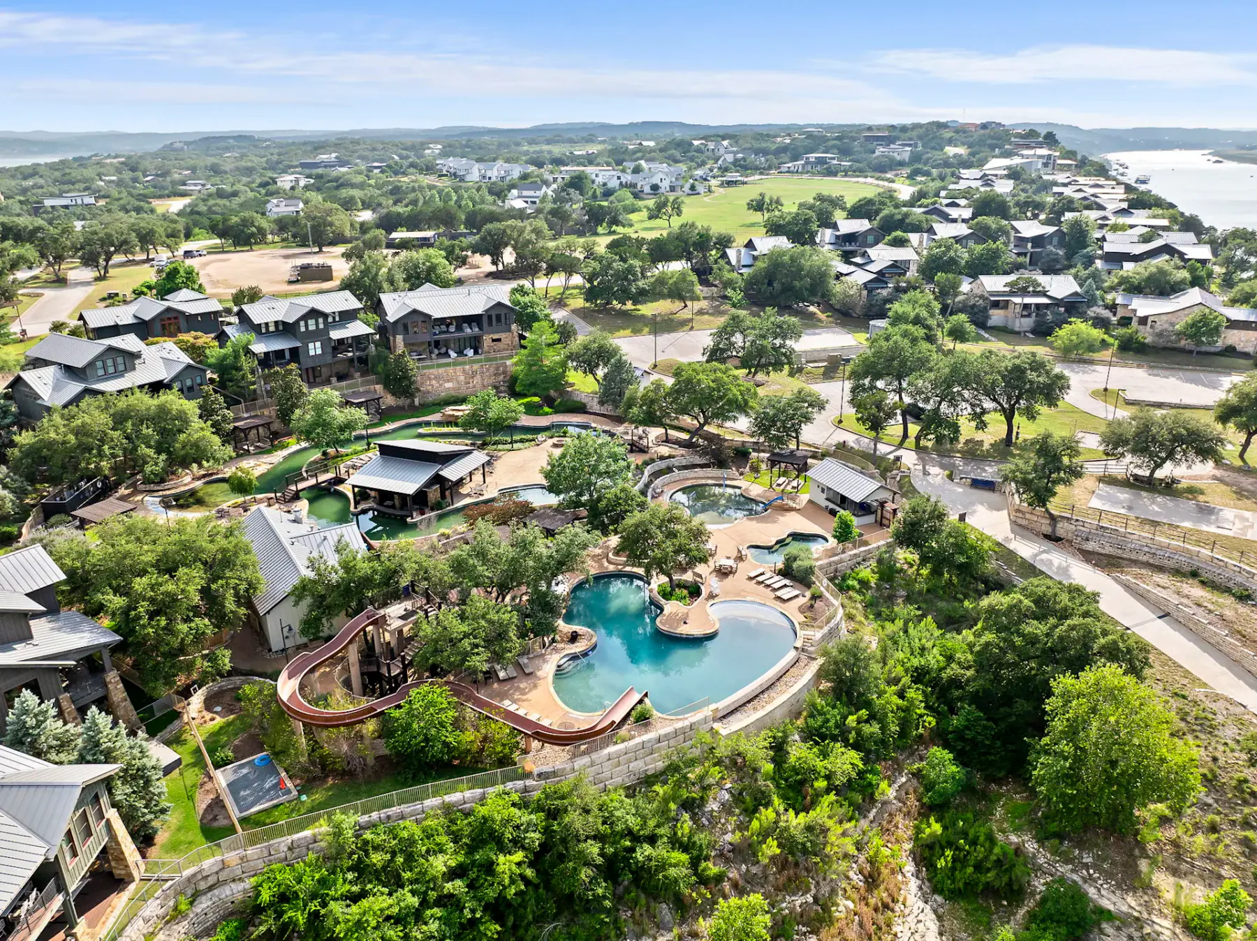 Shared amenity: Aerial view of a landscaped resort with swimming pools and surrounding buildings.