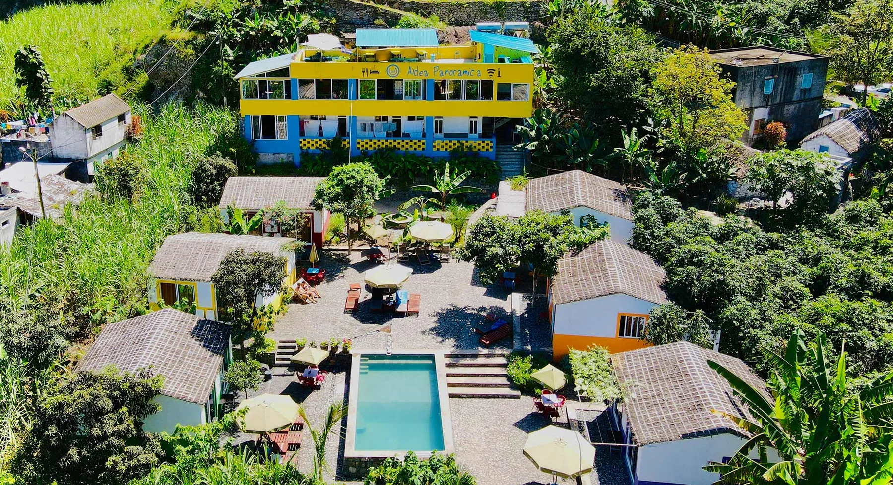 Representative hotel space: Aerial view of a lodging complex with a central pool and surrounding greenery.