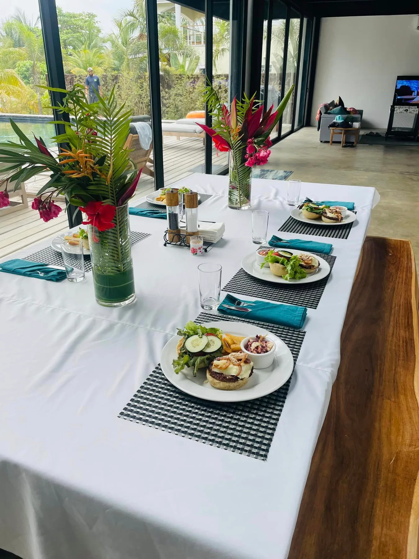 A dining table is set with plates of food and colorful floral arrangements.