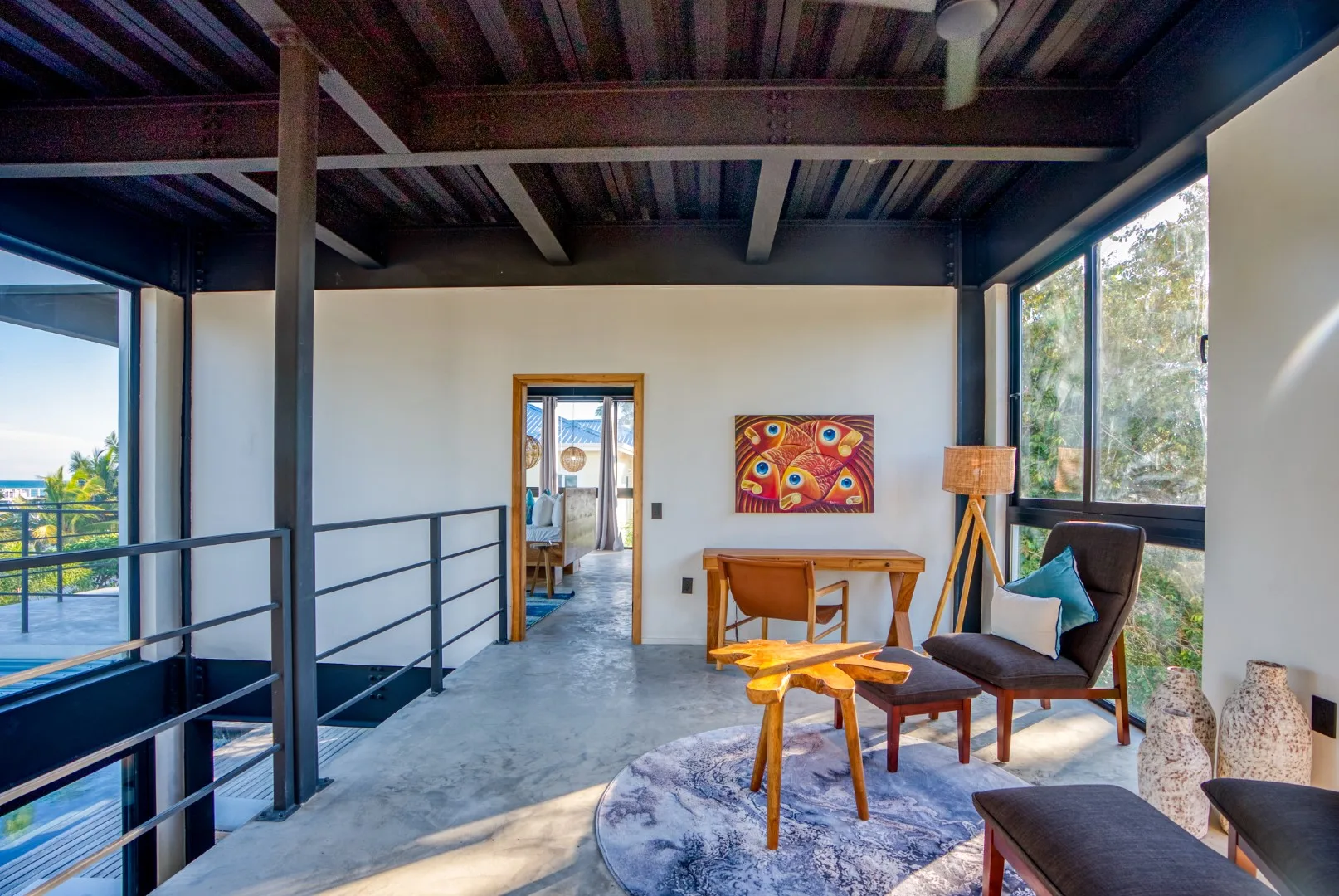 A bright seating area with a table, chairs, and large windows.