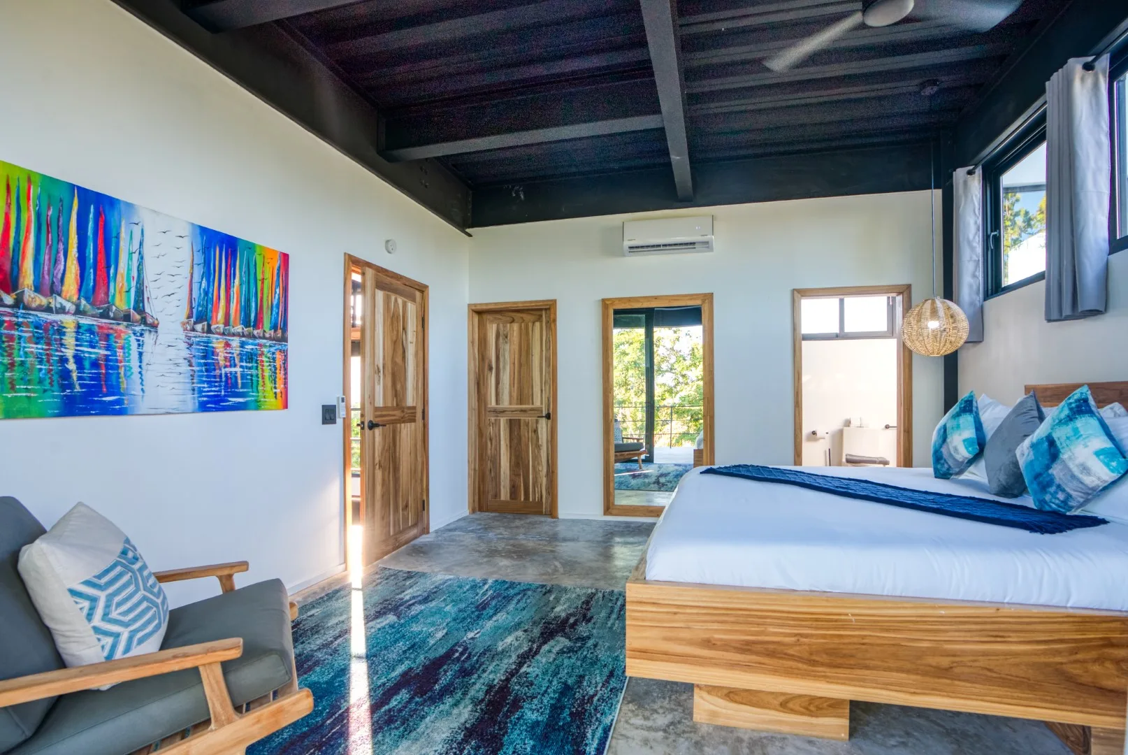 A bedroom with a wooden bed, colorful wall art, and a patterned rug.