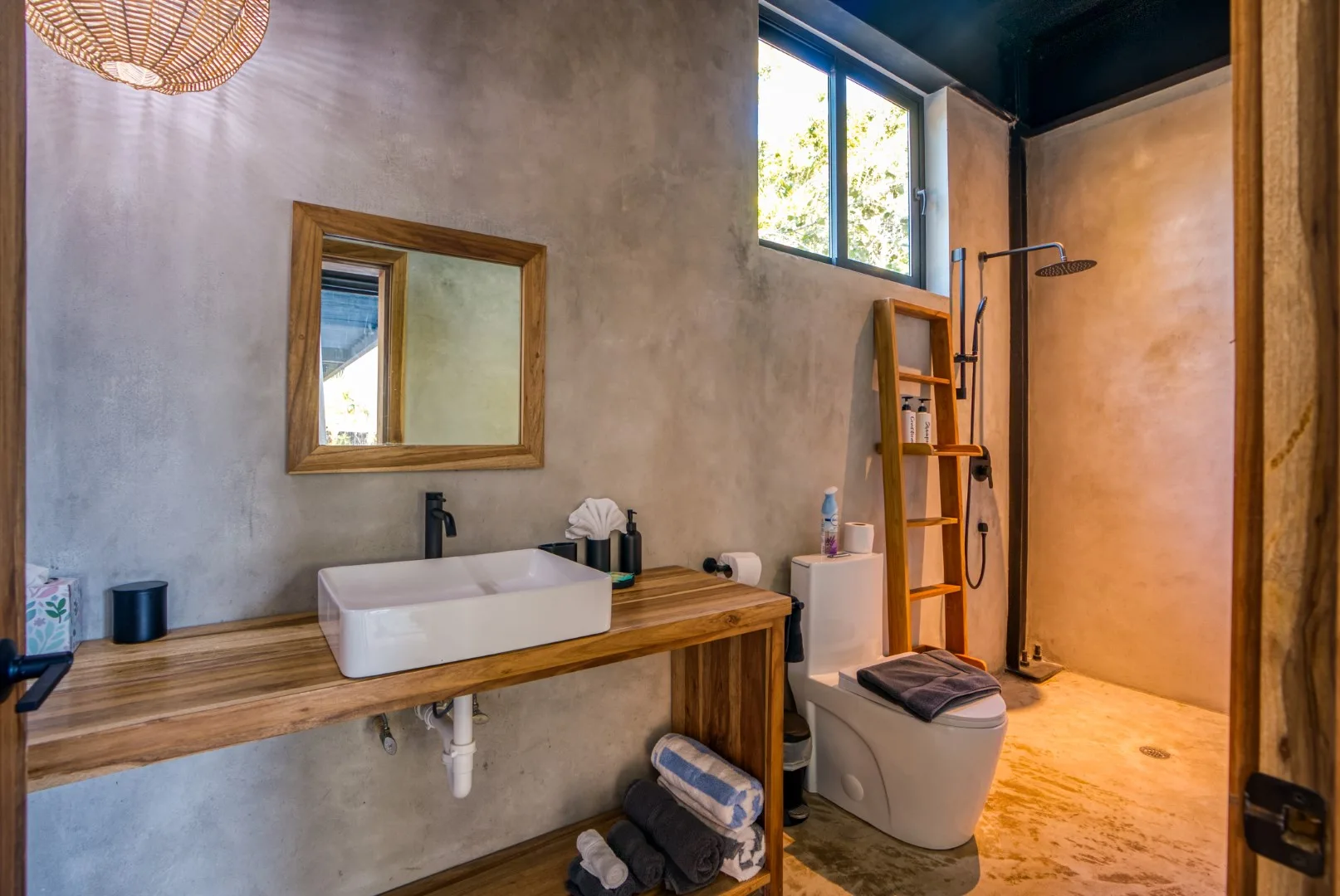 A bathroom with a sink, mirror, and open shower area.