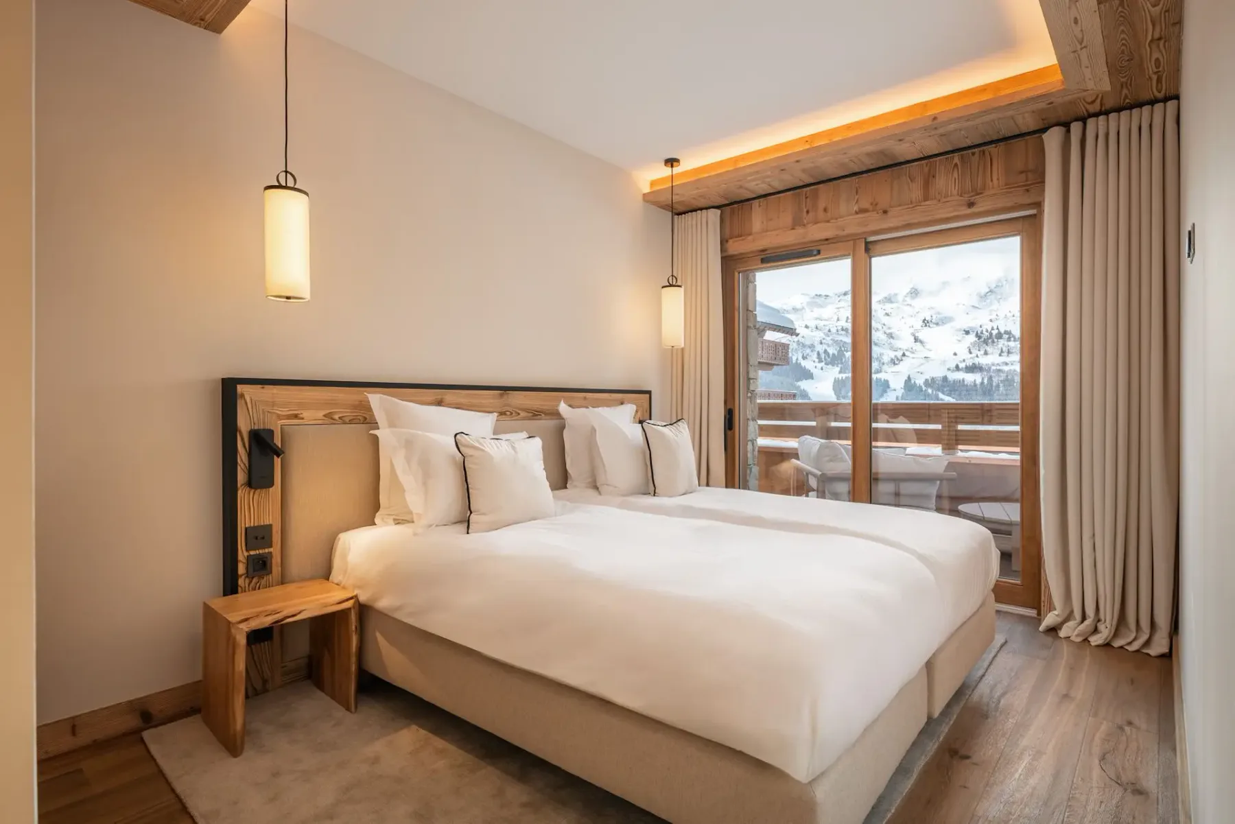 Dormitorio con una cama grande junto a puertas de vidrio que dan a un balcón.