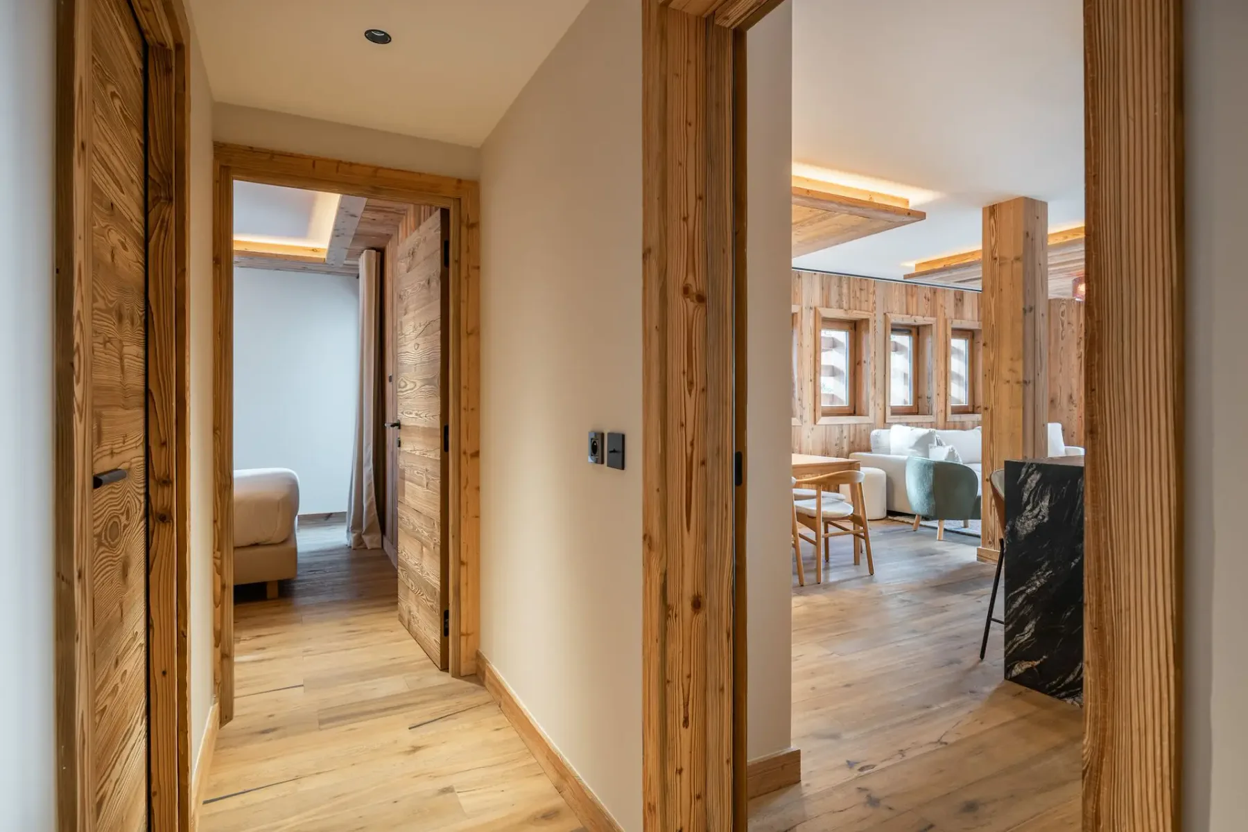 Un pasillo con molduras de madera da a un dormitorio y una sala de estar.