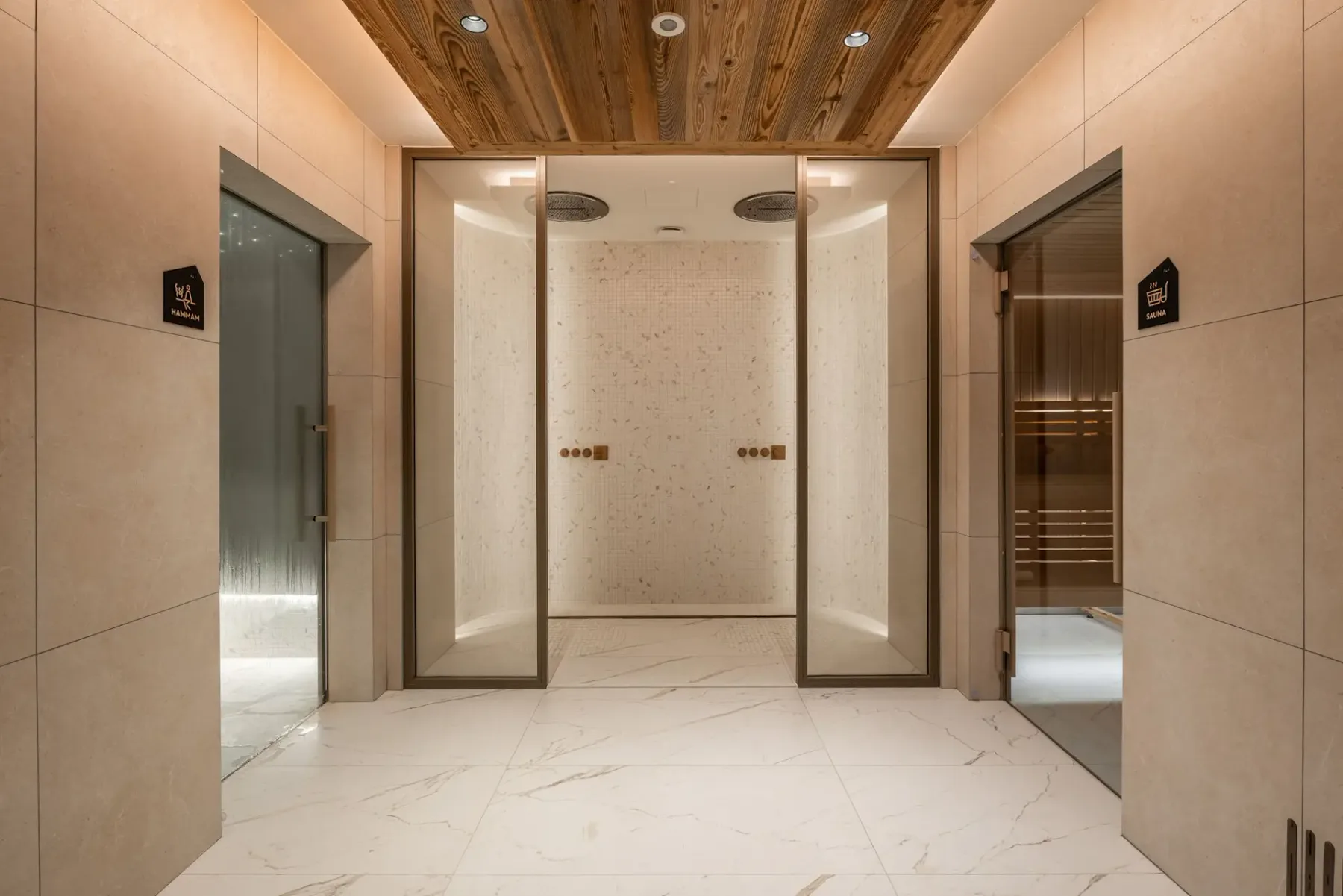 Zona común: Un pasillo de spa con paredes revestidas y accesos a zonas de baño.