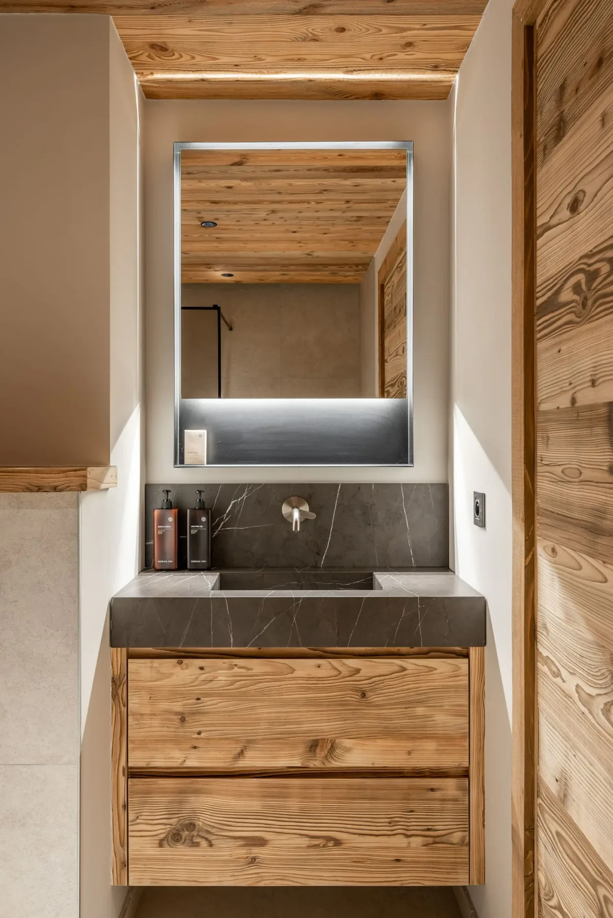 Un tocador de baño con lavabo está debajo de un espejo grande.