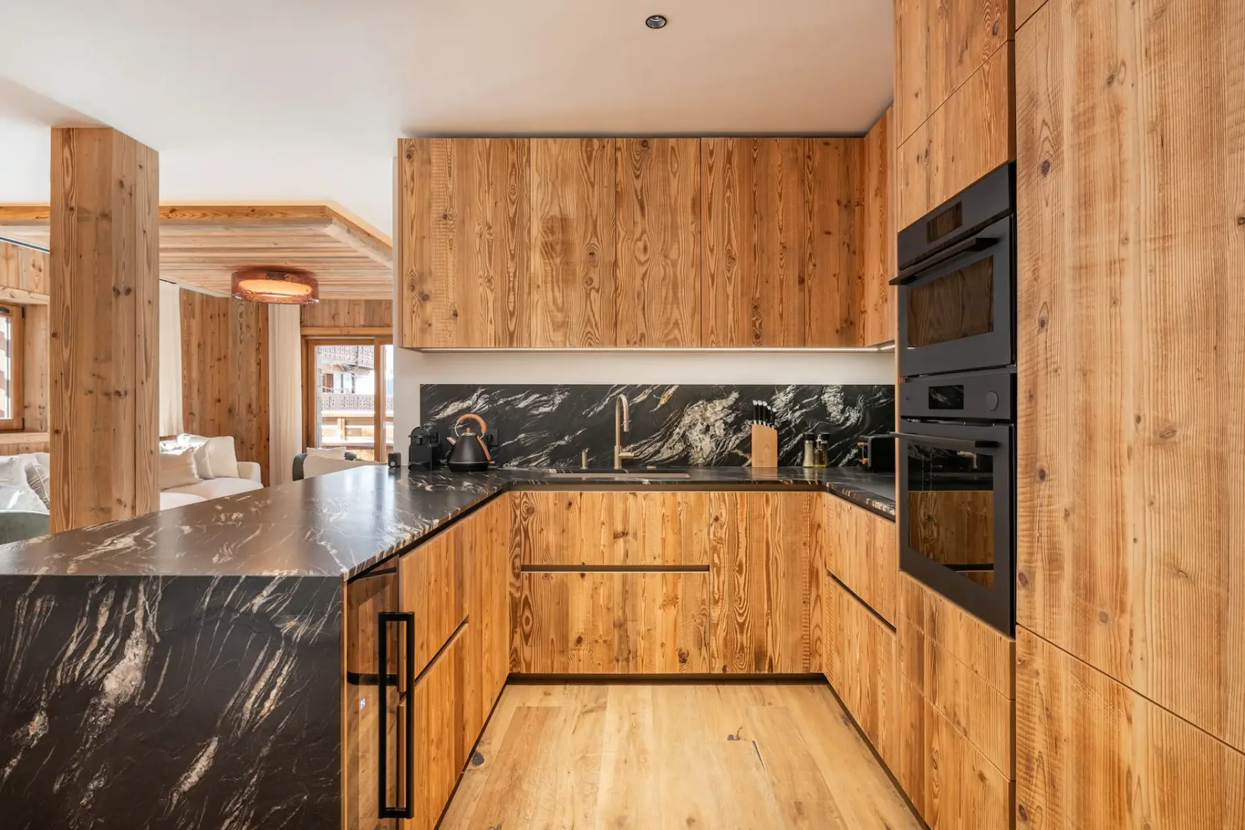 Una cocina con gabinetes de madera, encimeras oscuras y electrodomésticos empotrados.