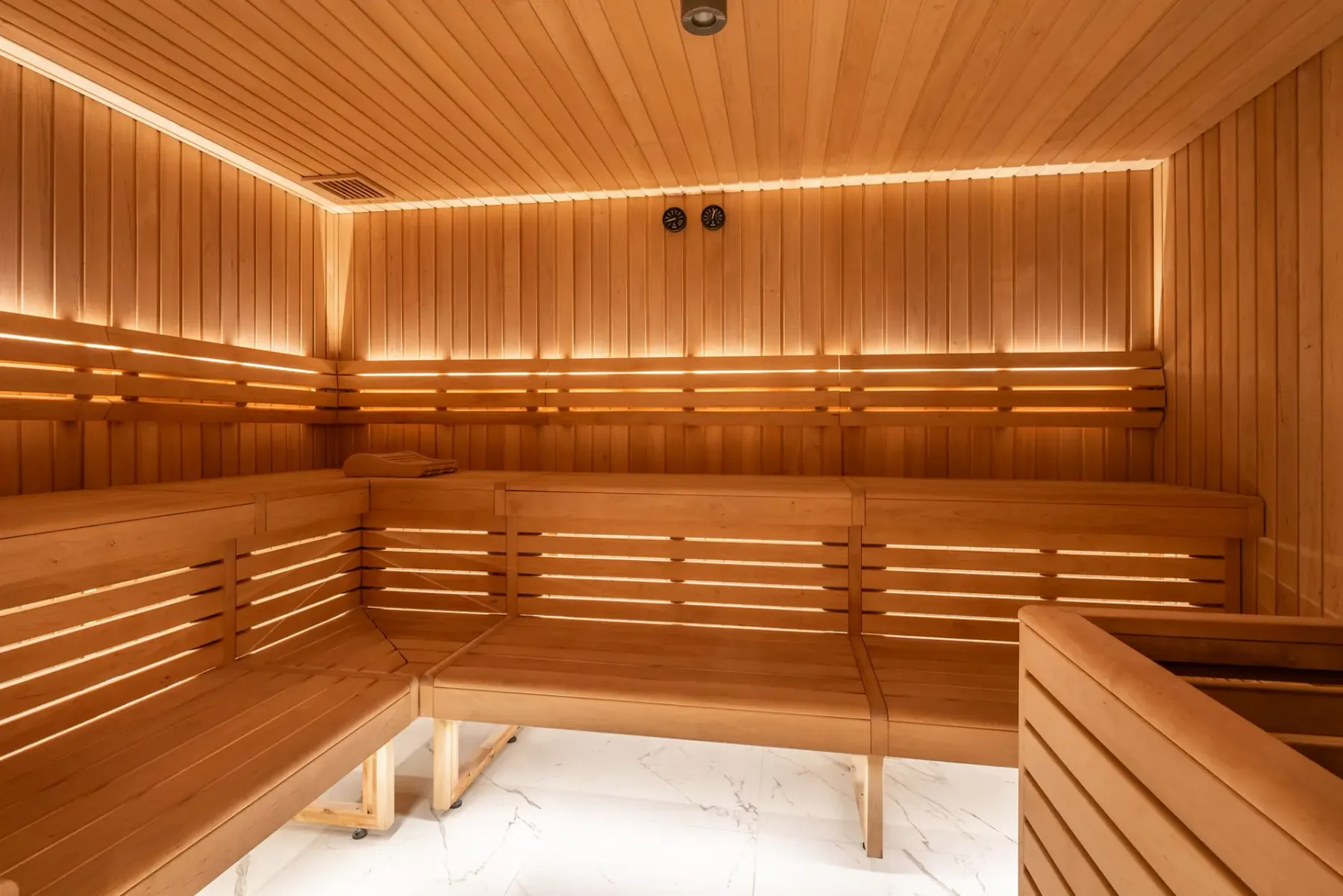 Zona común: Una sauna de madera con asientos en bancos escalonados.