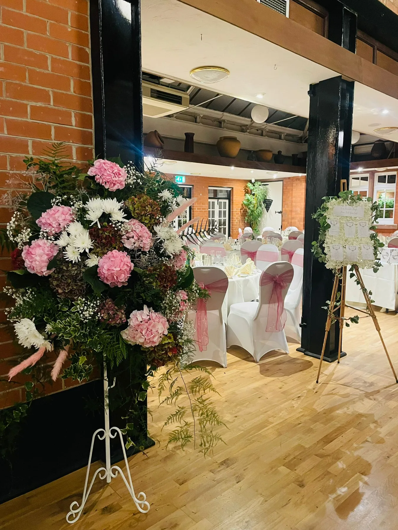 Espacio representativo del hotel: Un salón decorado para eventos con mesas, asientos y arreglos florales.