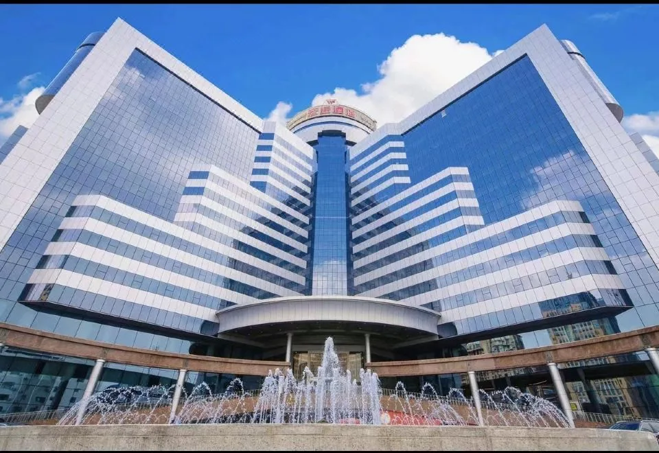 Representative hotel space: A modern glass-fronted building rises above a fountain plaza.