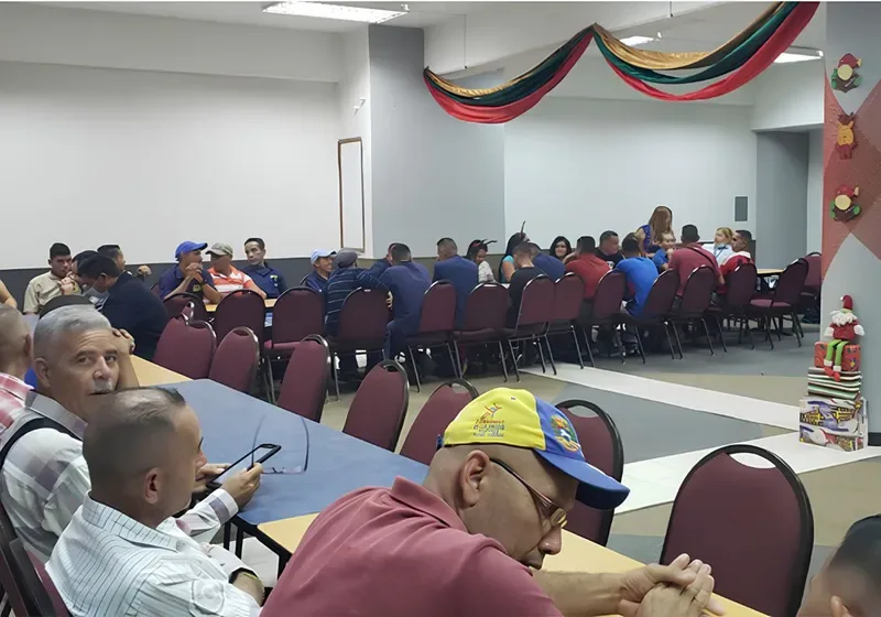 Espacio representativo del hotel: Una sala de reuniones con filas de sillas alrededor de mesas y personas reunidas.