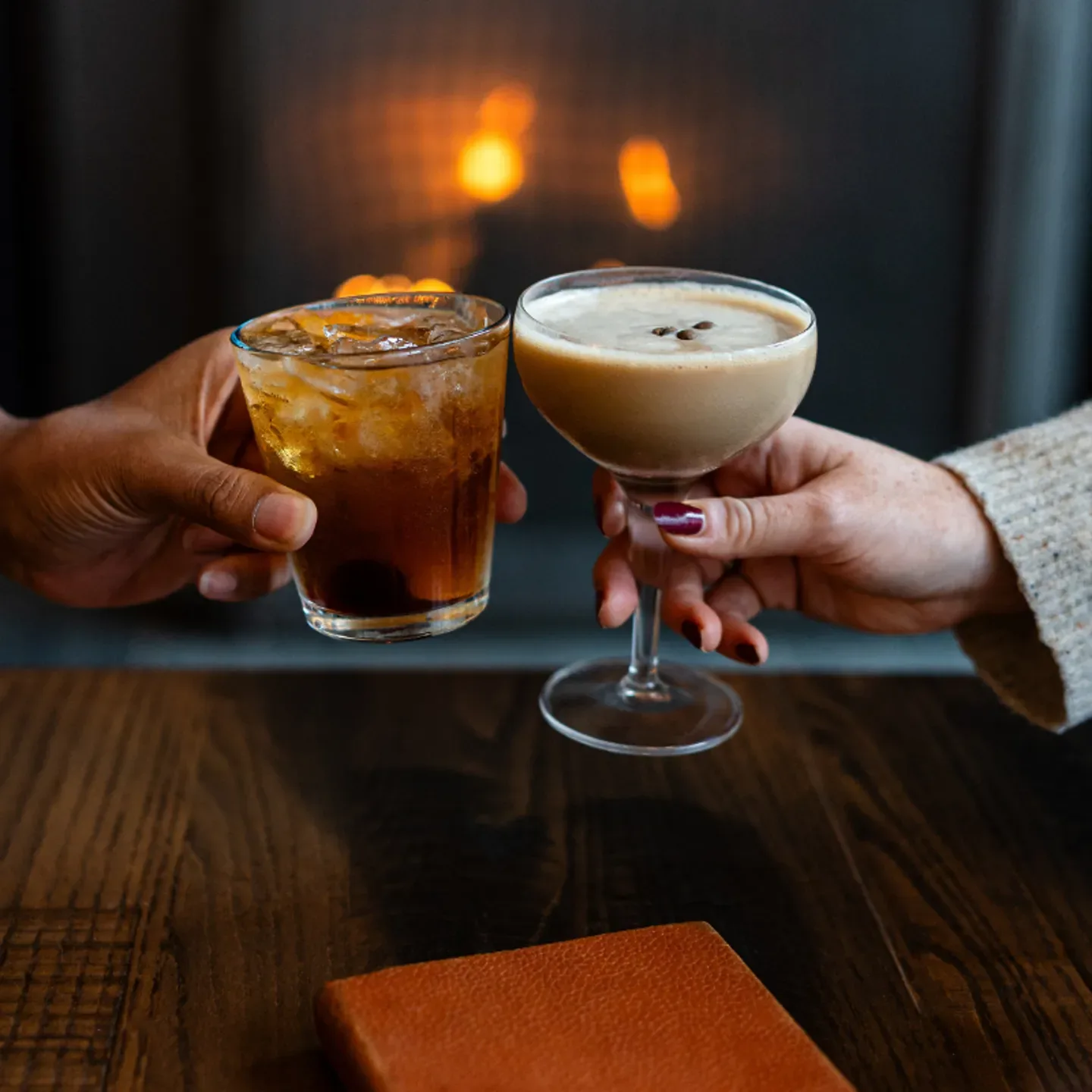 Espacio representativo del hotel: Dos bebidas se acercan sobre una mesa de madera oscura.