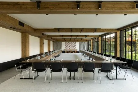 Representative hotel space: A conference room with long tables arranged in rows beside large windows.