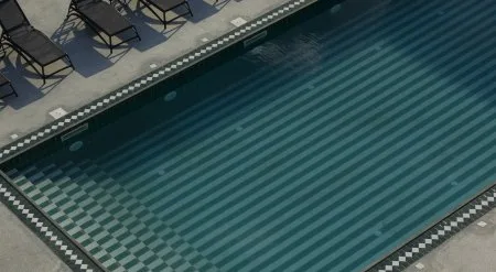 Representative hotel space: Outdoor swimming pool with patterned tiles and lounge seating along the edge.