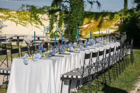 Representative hotel space: An outdoor dining area is arranged with long tables, chairs, and floral decorations.