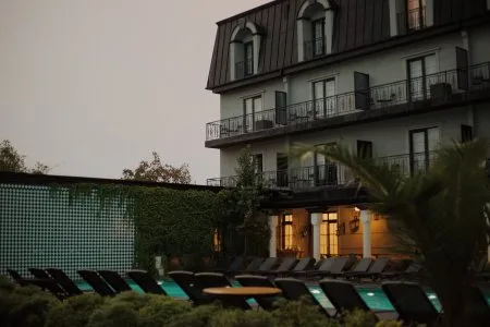 Representative hotel space: Outdoor poolside seating beside a hotel building at dusk.