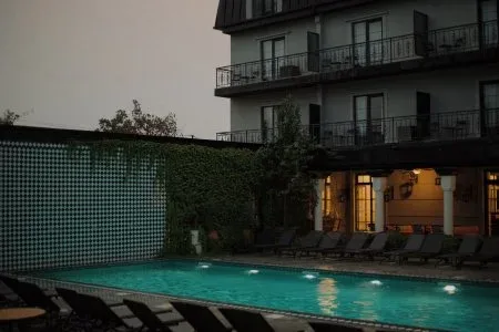 Representative hotel space: An outdoor swimming pool beside a multi-story building with balconies.
