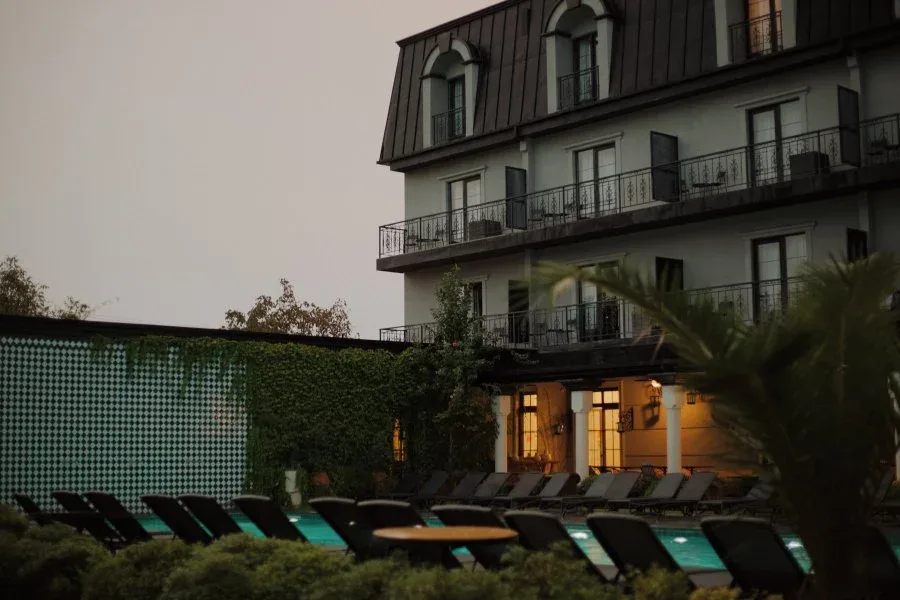 Representative hotel space: An outdoor pool with lounge seating beside a multi-story building.