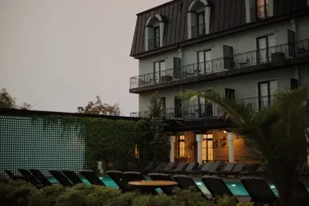 Representative hotel space: An outdoor pool area with rows of lounge chairs beside a multi-story building.
