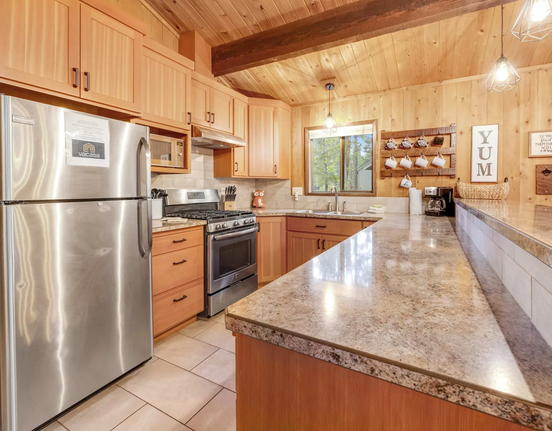 A wood-paneled kitchen with stainless steel appliances and a large central counter.