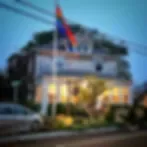 Representative hotel space: A hotel building with a flag above its illuminated entrance.