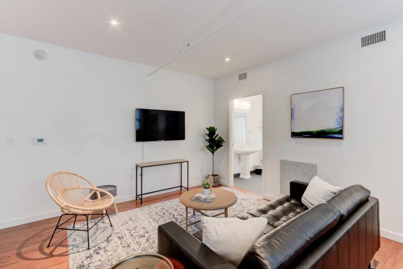 Una sala luminosa con asientos, un televisor y una alfombra.