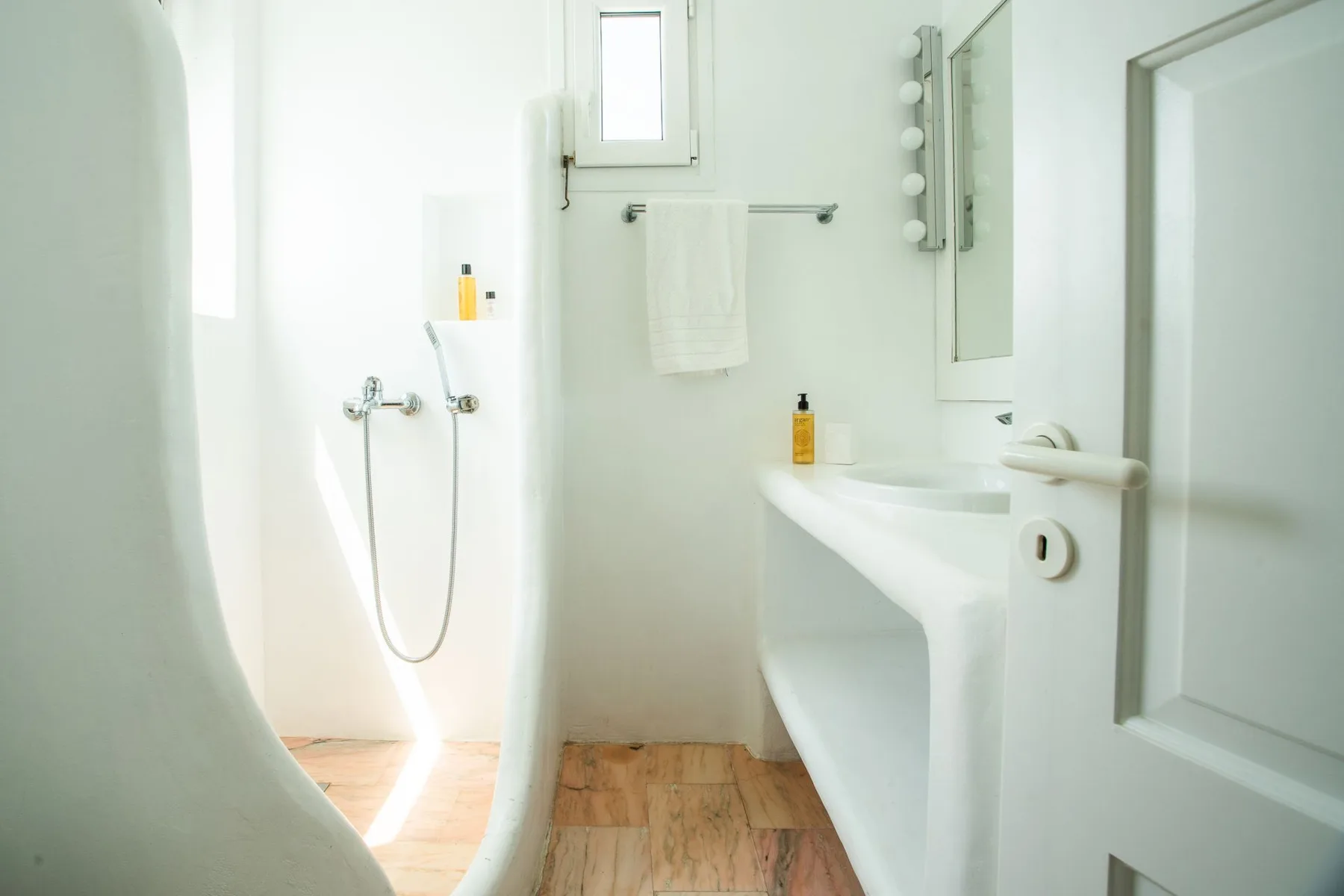 A bright bathroom with a bathtub, sink, and towel hanging on the wall.