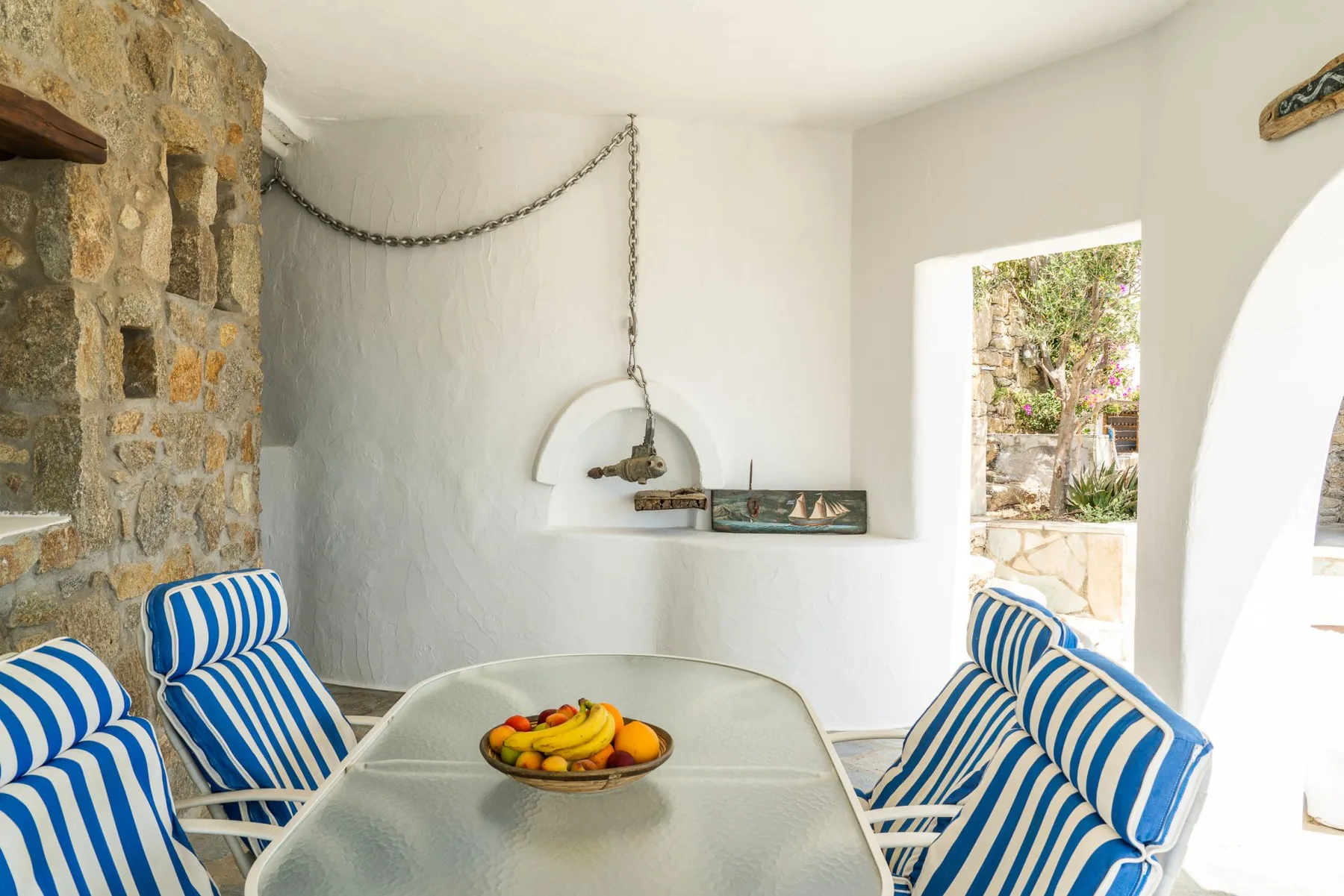 A bright dining area with a table and blue-and-white striped seating.