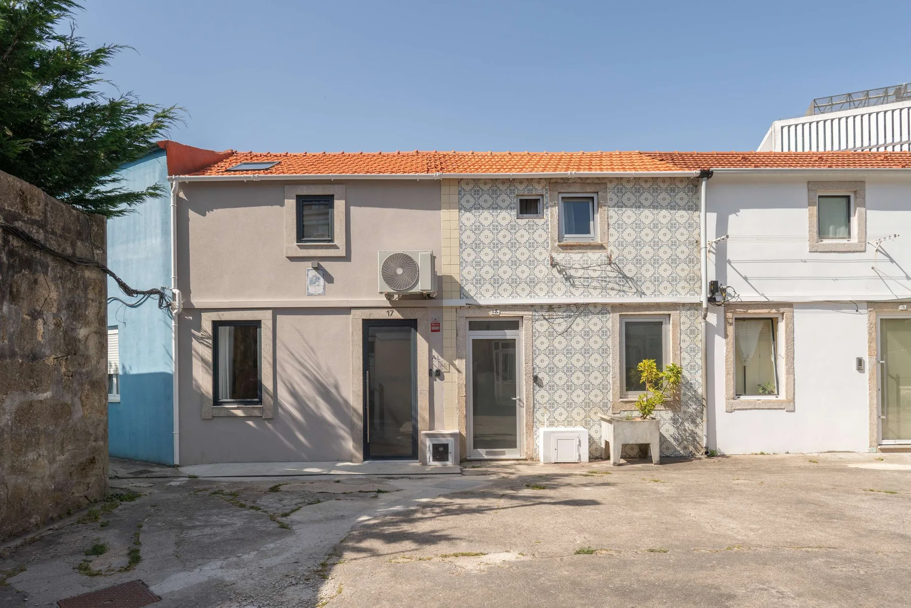 Zona común: Vista exterior de casas contiguas con una zona pavimentada delante.