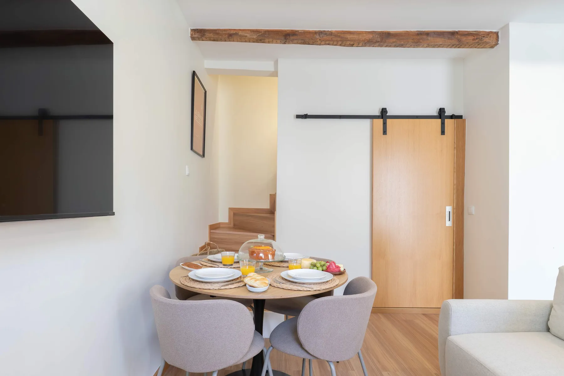 Comedor con una mesa redonda y asientos junto a una puerta corrediza de madera.